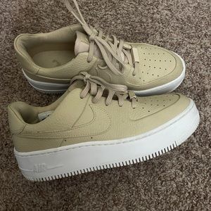 Nike Air Force 1s, tan leather with a white sole.